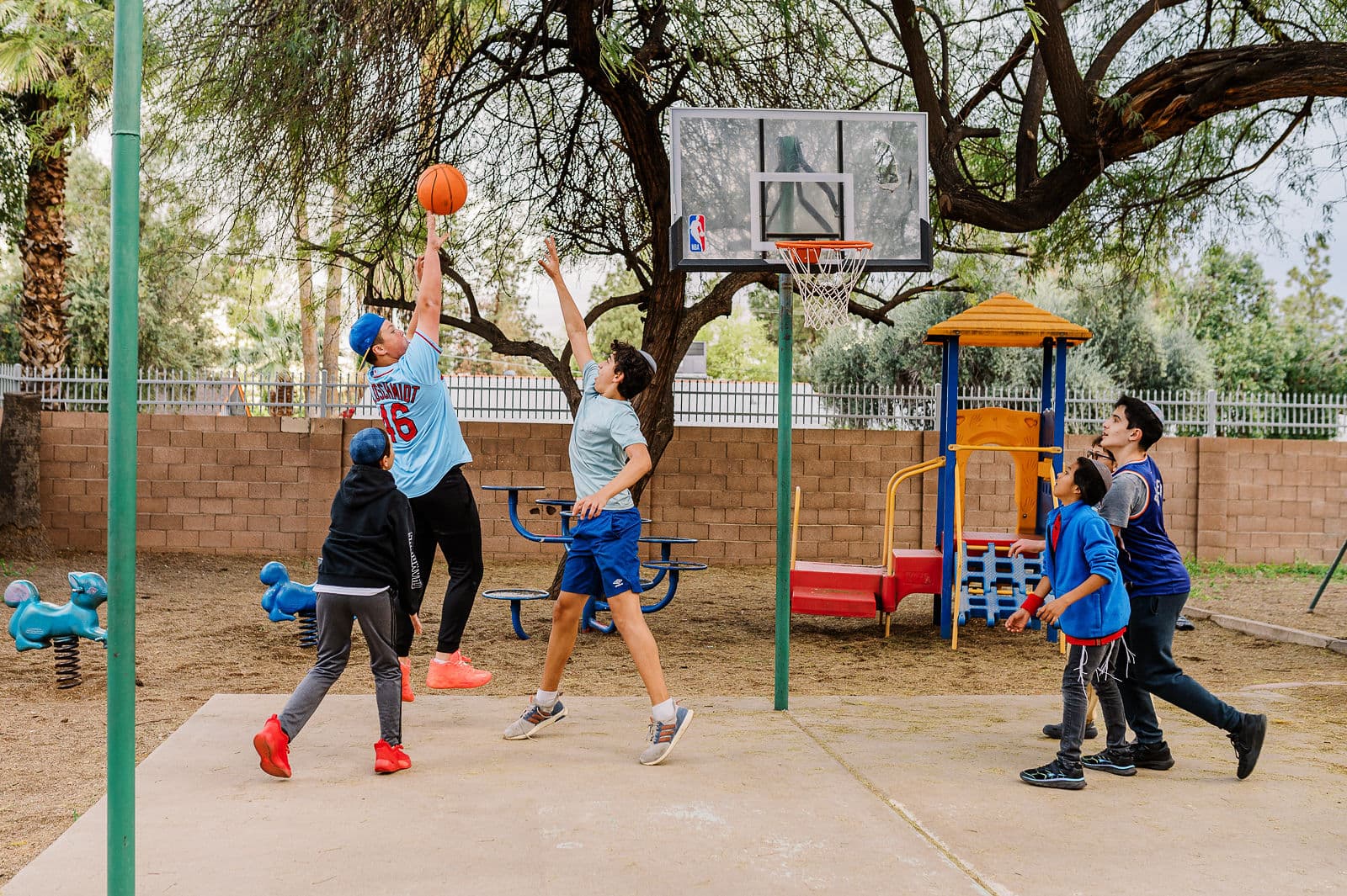 Teens playing basketball on the Beth Joseph campus court