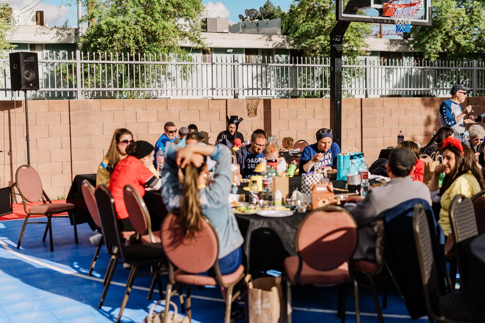Members sharing a meal at long tables on the campus court