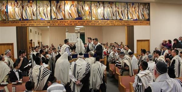 Members davening in the Beth Joseph sanctuary beneath the stained-glass windows