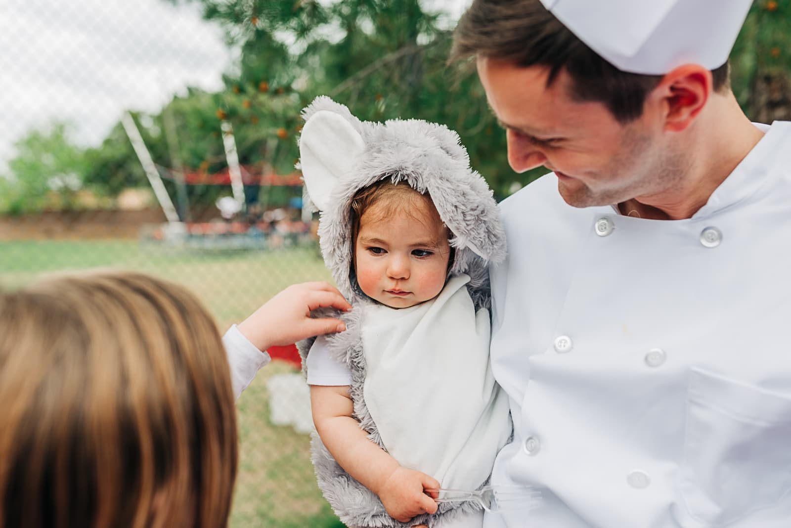 A father in costume holding his baby at the Purim seudah